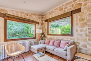 een woonkamer met een bank en 2 ramen bij Masia Ventanell Luxury villa near Barcelona in La Llacuna