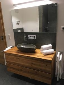 a bathroom with a stone sink and a mirror at Premium-Chalet Achental mit Kamin und Sauna in Schleching +18 photos
