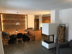 a living room with a table and a fireplace at Premium-Chalet Achental mit Kamin und Sauna in Schleching
