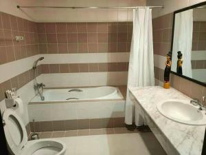 a bathroom with a tub and a toilet and a sink at Sandy Home in Ban Thai Don (2)