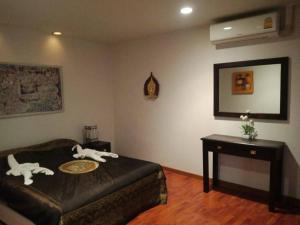 a bedroom with a bed and a table and a mirror at Sandy Home in Ban Thai Don (2)