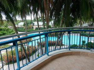 a balcony with a blue railing next to a swimming pool at Sandy Home in Ban Thai Don (2)