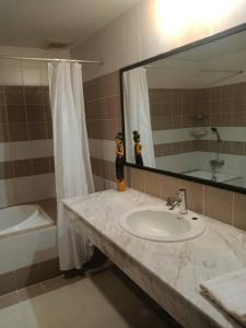 a bathroom with a sink and a mirror and a tub at Sandy Home in Ban Thai Don (2)