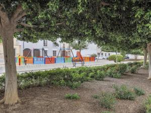 een park met een kleurrijke speeltuin op de achtergrond bij Alcalá del rio! bajo B in Alcalá del Río