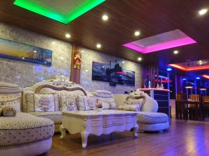 ナラタニヤにあるDaddy's Guest Homeの白いソファ、テーブル、照明が備わる客室です。