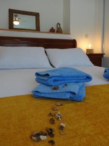 1 dormitorio con 1 cama con toallas azules y zapatos en el suelo en Casa Rural Mirando a la Peña "Grupo Mirando a Gredos", en Cadalso de los Vidrios