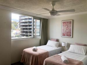two beds in a room with a window at Oceania on Burleigh Beach in Gold Coast +85 photos