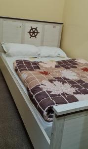 a bed with a brown and white blanket on it at Dubai Hostel, Bedspace and Backpackers in Dubai