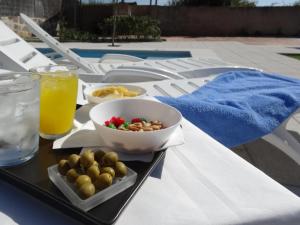 a tray of food with a bowl of olives and a drink at Casa Rural Mirando a la Peña "Grupo Mirando a Gredos" in Cadalso de los Vidrios