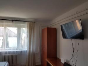 um quarto com uma televisão de ecrã plano na parede em Kuckó Apartman Berente em Berente