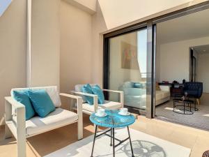 a living room with two chairs and a table at Jardines de Montesolana Penthouse - 2110 in Los Dolses