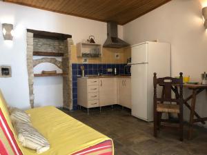a kitchen with a refrigerator and a table with a chair at Casa Leonor Vejer in Vejer de la Frontera