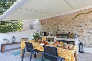 a table with a yellow table cloth on a patio at Les Chambres du Lavoir Vert in Tourbes