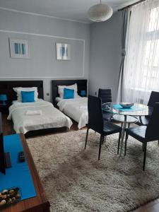 a bedroom with two beds and a table and chairs at Sleep Well in Poznań