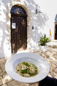 a bowl of food on a plate in front of a door at Masseria Borgo Santuri in Ostuni