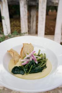 a white plate of food with bread and vegetables at Masseria Borgo Santuri in Ostuni