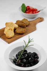 a plate of olives and bread on a cutting board at Masseria Borgo Santuri in Ostuni