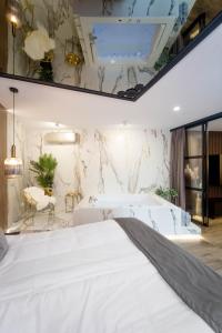 - une chambre avec un lit blanc et un mur en marbre dans l'établissement Jacuzzi Apartment Main Square, à Cracovie