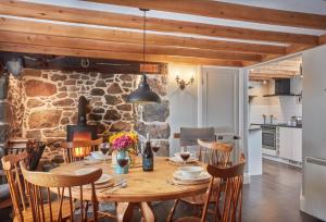 a kitchen and dining room with a wooden table and chairs at Prospect House in Coverack