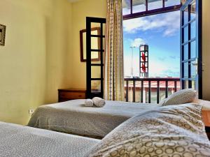 プエルト・デ・ラ・クルスにあるCozy apartment in old quarter of Puerto de la Cruzのベッドルーム1室(ベッド2台、大きな窓付)