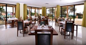 un ristorante con tavoli e sedie in legno e finestre di Vila Gale Atlantico ad Albufeira