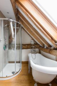 a bathroom with a glass shower and a tub at Old Barn Cottage in Horley +33 photos