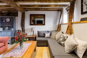 a living room with a couch and a table at Old Barn Cottage in Horley