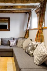 a couch with pillows on it in a living room at Old Barn Cottage in Horley