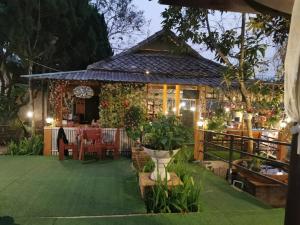 a patio with a table and a building with plants at Mon Kiang-Dao Resort in Chiang Dao