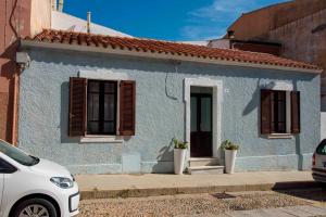 a blue house with a white car parked in front of it at La casa di Nì in Santa Teresa Gallura