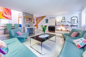 Villa Mia في ترستنو: غرفة معيشة مع أرائك زرقاء ومدفأة