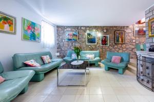 uma sala de estar com sofás azuis e uma mesa em Villa Mia em Trsteno