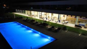 a large building with a swimming pool at night at Golden Tulip Porto-Vecchio in Porto-Vecchio