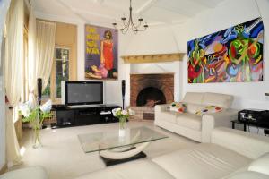 sala de estar con sofá blanco y chimenea en Villa Horizon Bleu, en Cannes