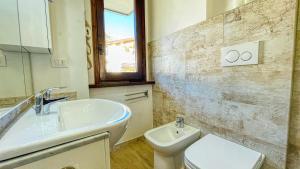 y baño con lavabo, aseo y espejo. en Appartamento Winter Garden - Affitti Brevi Italia, en Bardonecchia