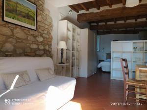 una camera con un letto bianco e un muro in pietra di Casa Toscana Mugello a Barberino di Mugello