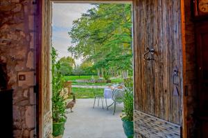 an open door leading to a garden with a table and chairs at Bastide de Bellegarde in Avignon