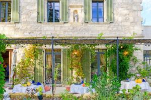 an outdoor dining area with white tables in front of a building at Bastide de Bellegarde in Avignon
