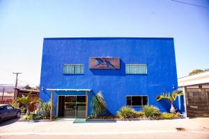 a blue building with a window on the side of it at Pousada Araras in Alto Paraíso de Goiás