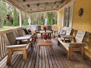 a porch with wooden benches and tables and chairs at Horrmundsgården i Sälen in Sälen