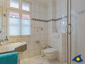 a bathroom with a toilet and a sink and a shower at Villa Vineta Whg 08 in Bansin