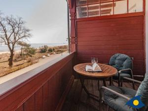 een houten tafel en stoelen op een veranda met een raam bij Villa Vineta Whg 11 in Bansin