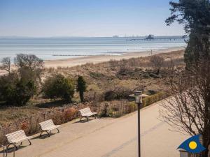 twee banken op een stoep bij een strand bij Villa Vineta Whg 11 in Bansin