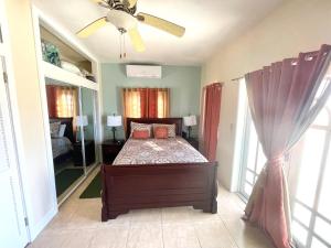Schlafzimmer mit einem Bett und einem Deckenventilator in der Unterkunft Wintberg Tropical Villas in Mandal