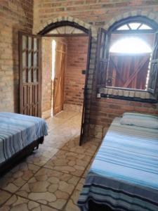 - une chambre avec 2 lits dans un mur en briques dans l'établissement Chalé Rústico, à Palmeiras