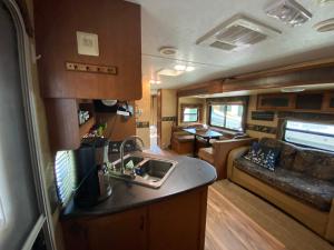 an rv kitchen with a sink and a couch at Water Front Tracer RV by Glampers Camp in Port Charlotte