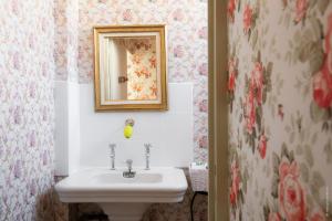 La salle de bains est pourvue d'un lavabo et d'un miroir. dans l'établissement Hotel de Charme La Bonne Adresse, au Havre