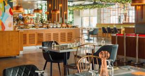 a restaurant with tables and chairs and a counter at C Central Hotel and Resort The Palm in Dubai