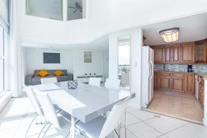 una cucina e una sala da pranzo con tavolo e sedie bianchi di Girasole Rentals a Miami Beach