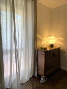 una lampada sopra un comò accanto a una finestra di Casa B&B Fontanelle a Iseo